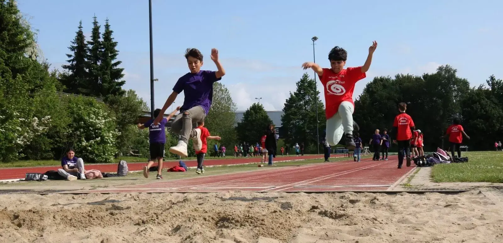 Twee jongens springen samen ver