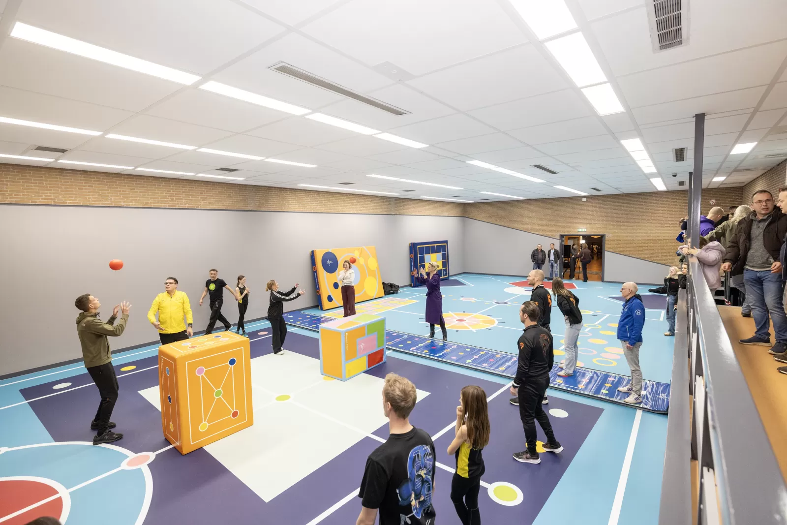Aantal mensen gooien bal over in kleurrijke sportzaal