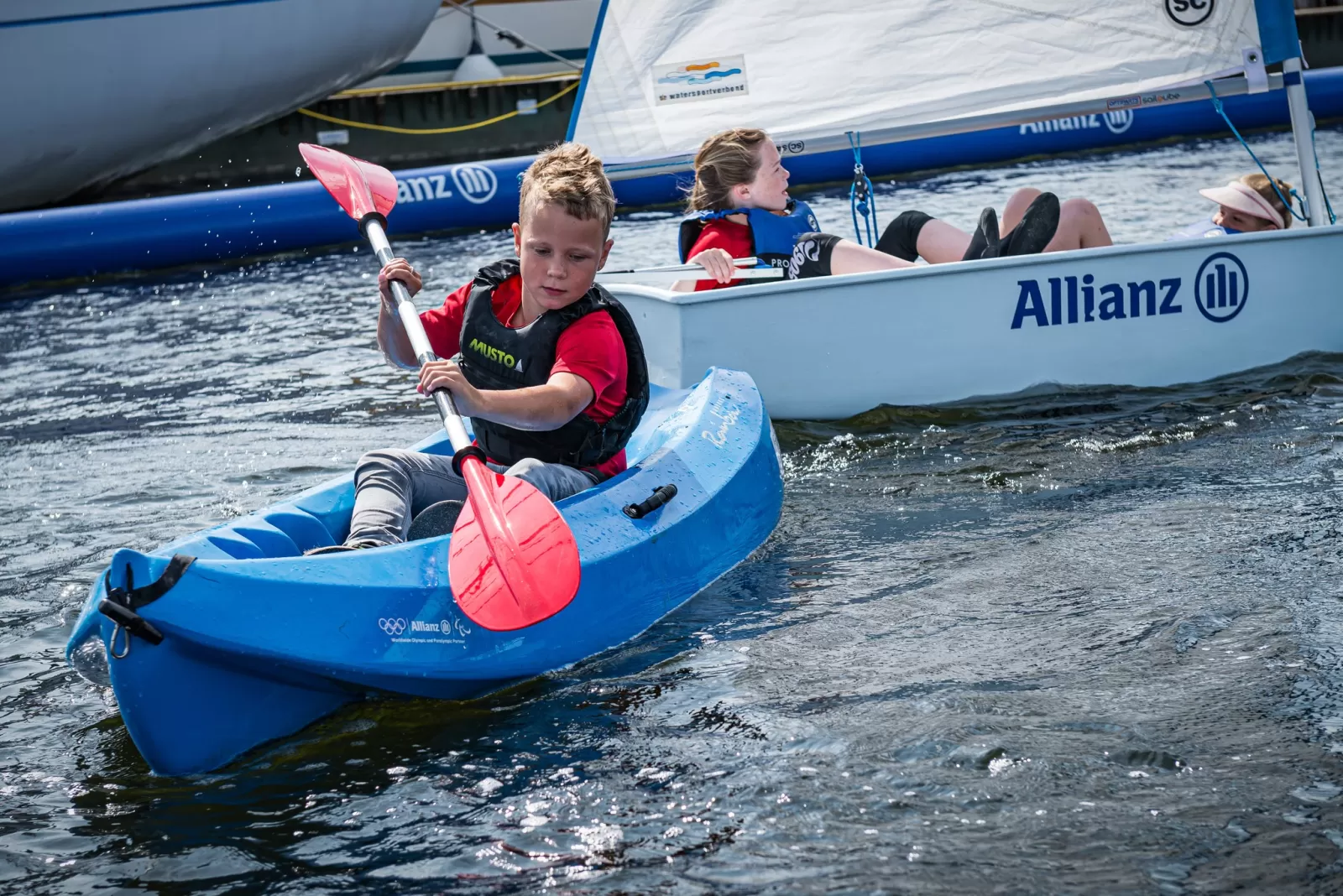 kinderen in zeilbootje en kano